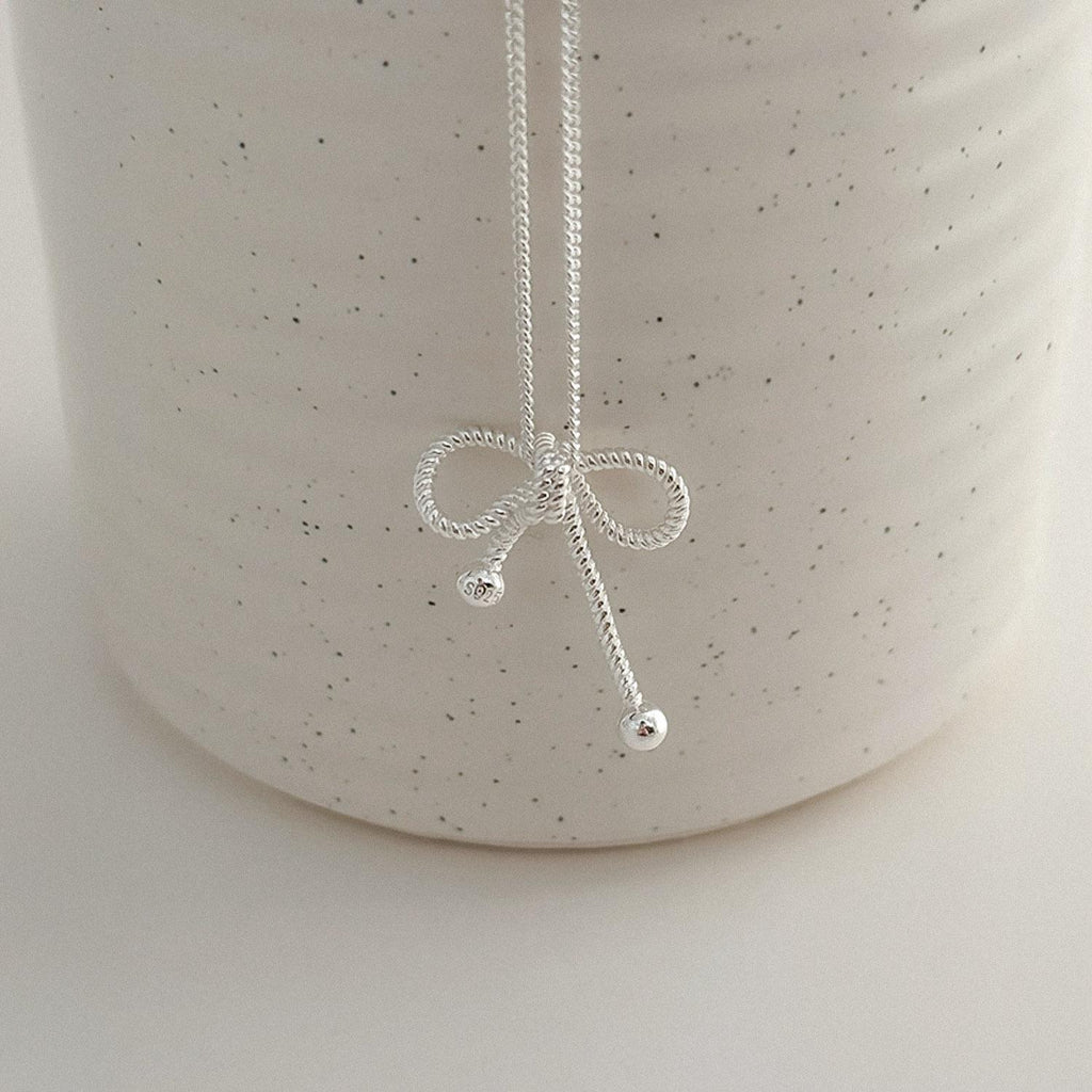 lose-up detail of a sterling silver rope bow pendant necklace