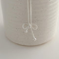 lose-up detail of a sterling silver rope bow pendant necklace