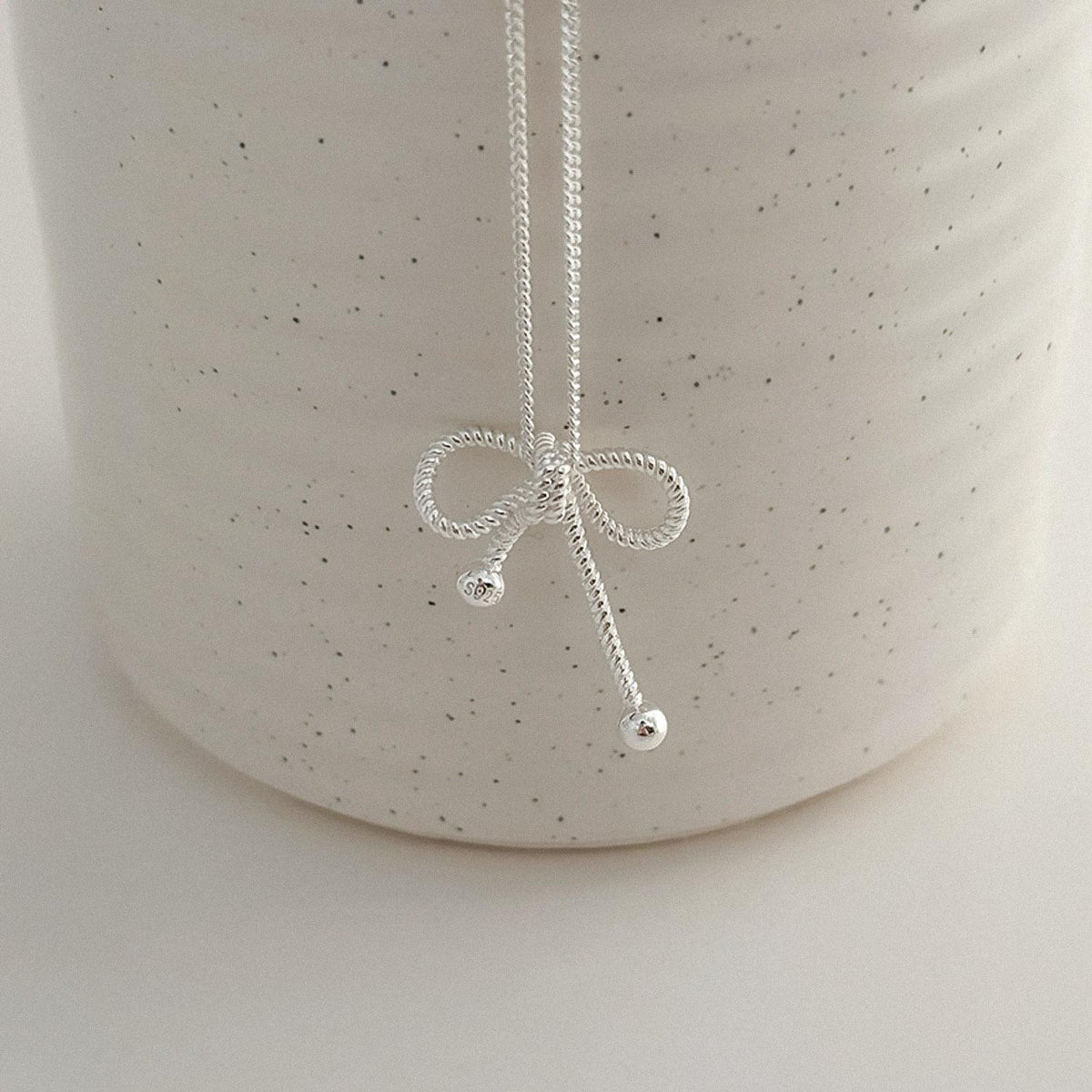lose-up detail of a sterling silver rope bow pendant necklace